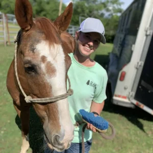 Gracie standing next to her horse, Slinger, after a show